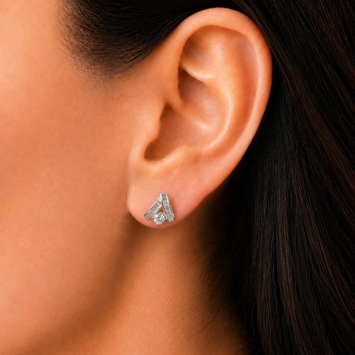 Close-up of a woman wearing the Veyra Duet Zircon Stud, showcasing its contemporary geometric silver-tone design with baguette-cut and round-cut clear zircon stones.