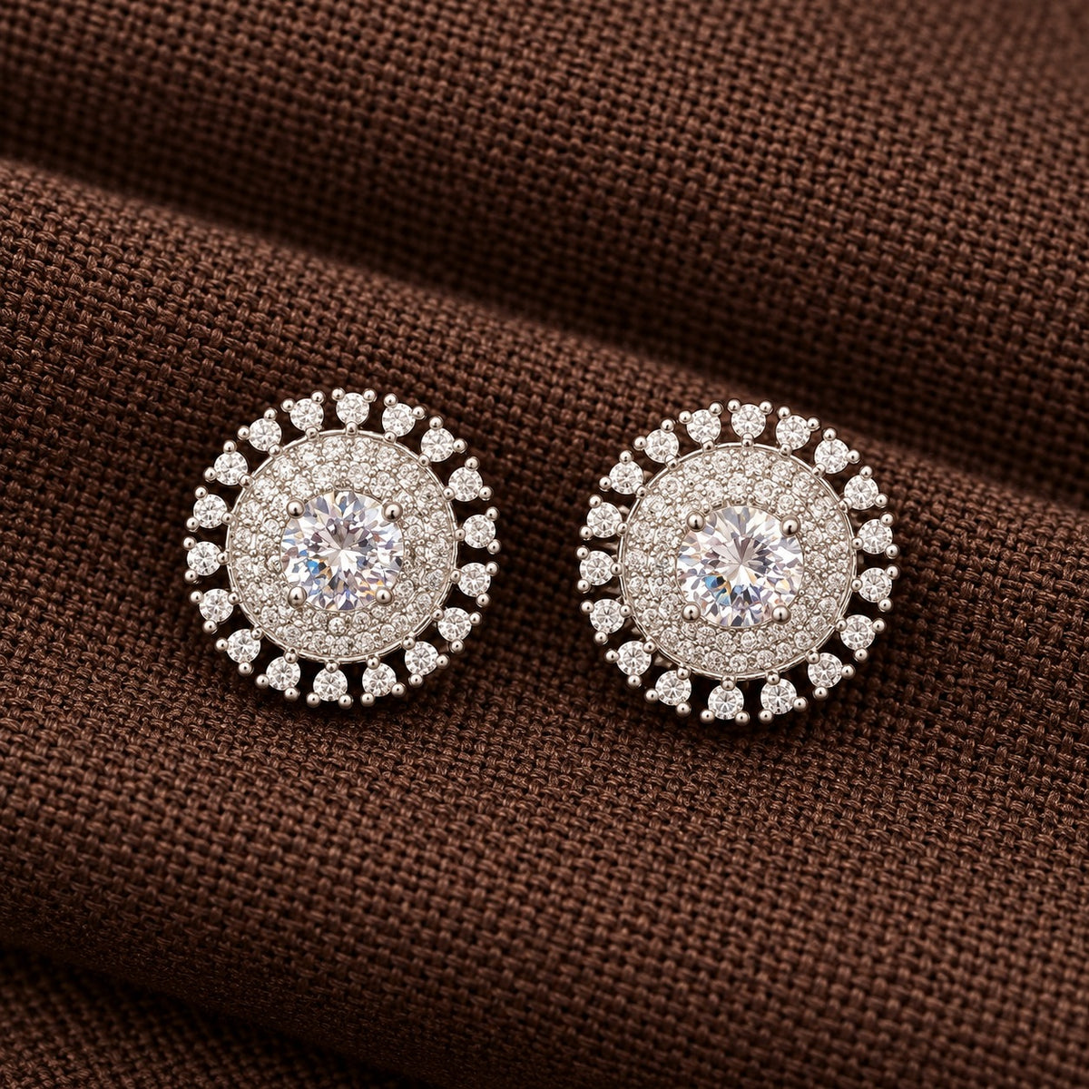 Regent Medallion Studs featuring a faceted clear  centre stone, delicate clear zircon detailing, and an outer circle of clear gemstones in a polished silver-tone setting.