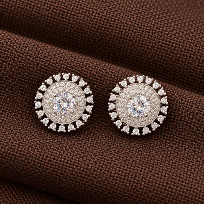 Regent Medallion Studs featuring a faceted clear  centre stone, delicate clear zircon detailing, and an outer circle of clear gemstones in a polished silver-tone setting.