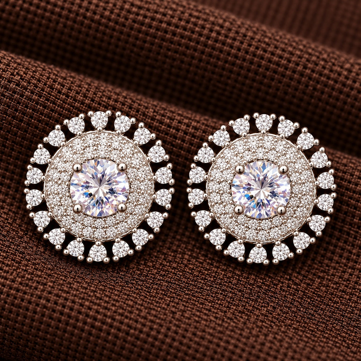 Detailed close-up of the Regent Medallion Studs in crystal clear, revealing the faceted centre stone, finely arranged clear zircons, and surrounding ruby red gemstones.
