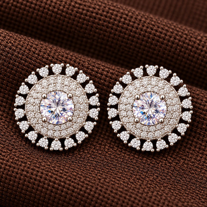 Detailed close-up of the Regent Medallion Studs in crystal clear, revealing the faceted centre stone, finely arranged clear zircons, and surrounding ruby red gemstones.