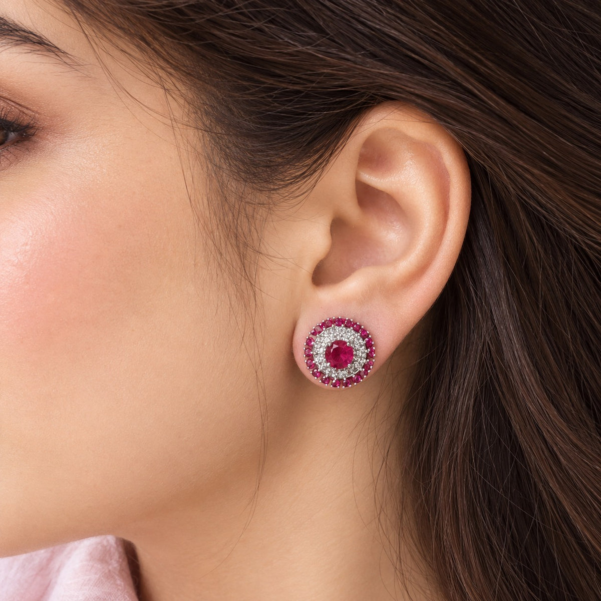 Close-up of a model wearing the Regent Medallion Studs in Raspberry pink, showcasing the circular gemstone design and its beautiful proportion on the earlobe.