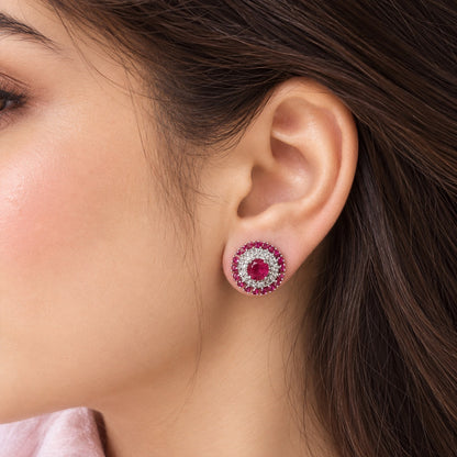 Close-up of a model wearing the Regent Medallion Studs in Raspberry pink, showcasing the circular gemstone design and its beautiful proportion on the earlobe.
