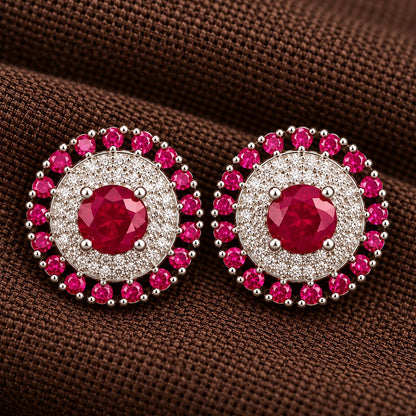 Detailed close-up of the Regent Medallion Studs in Raspberry pink , revealing the faceted centre stone, finely arranged clear zircons, and surrounding ruby red gemstones.