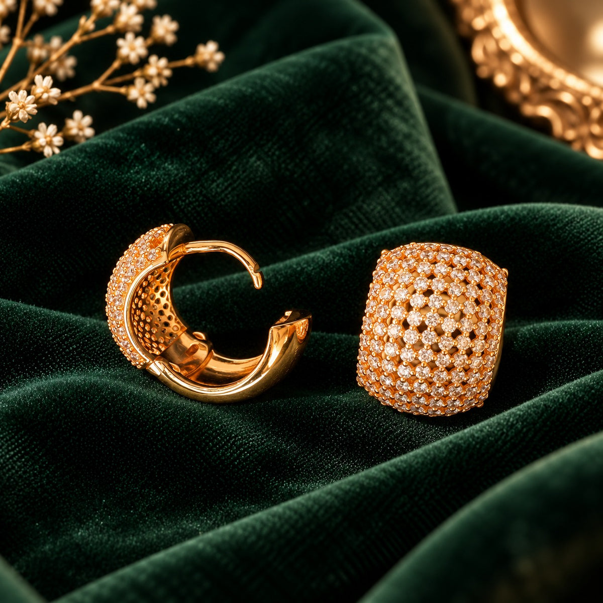 Gilded Mosaic Huggie Earrings displayed on forest green velvet, showing the hinged hoop construction, smooth gold-tone interior and secure click-lock fastening