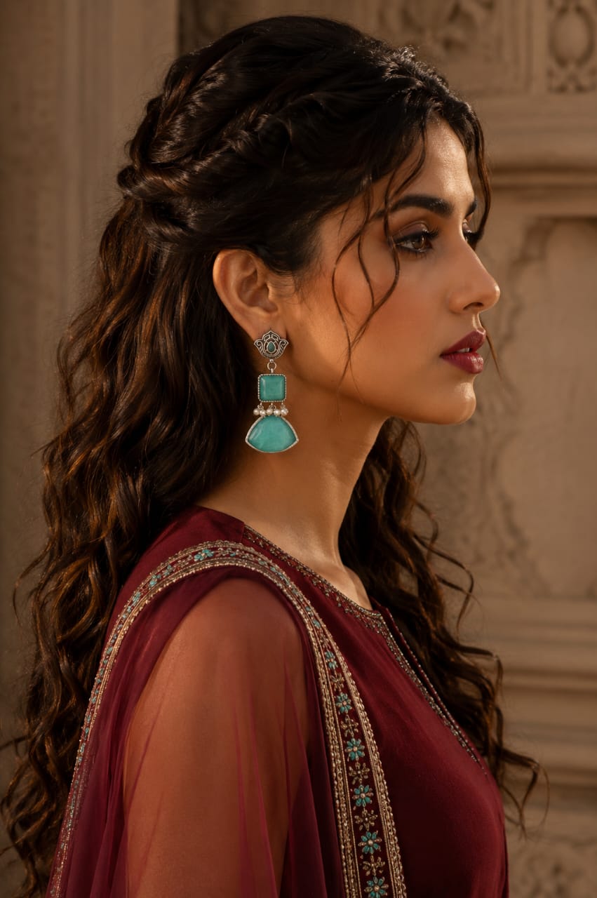 Woman wearing Legacy Collection antique mint green statement earrings with pearl detailing in a side profile.