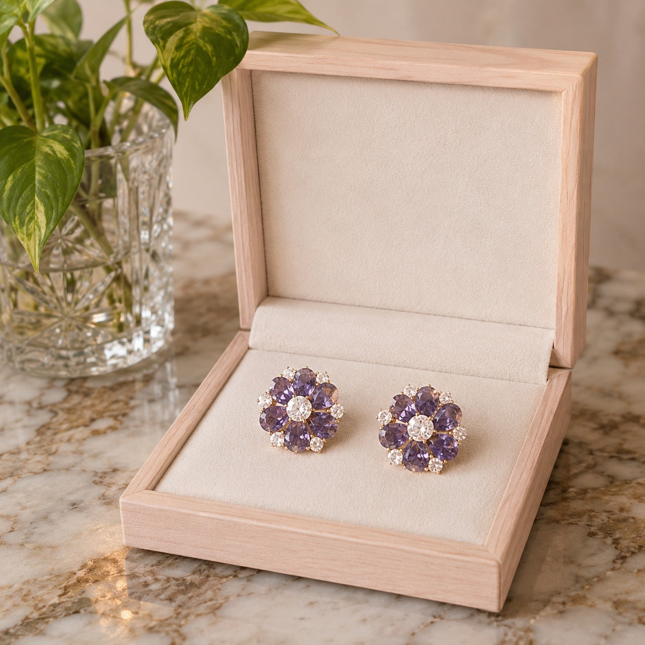 Lavender purple floral crystal stud earrings displayed in a premium wooden jewelry box on a marble surface.
