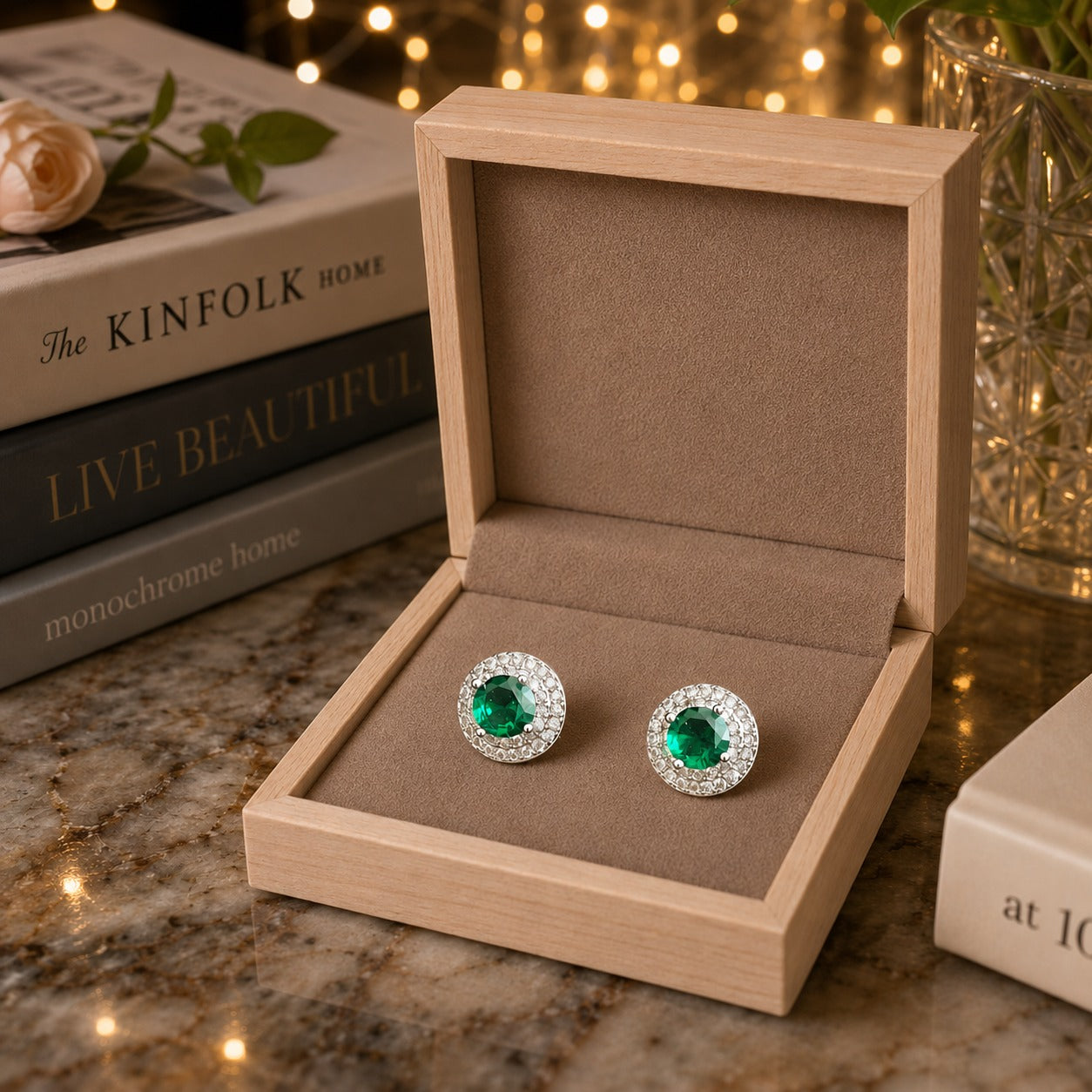 Emerald green halo crystal stud earrings presented in a premium taupe velvet jewelry box.