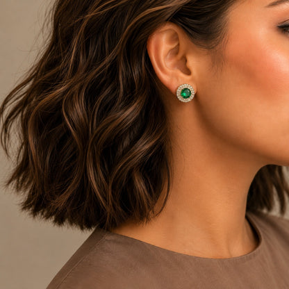Emerald green halo gemstone stud earrings worn on model with sparkling silver-tone crystal halo.