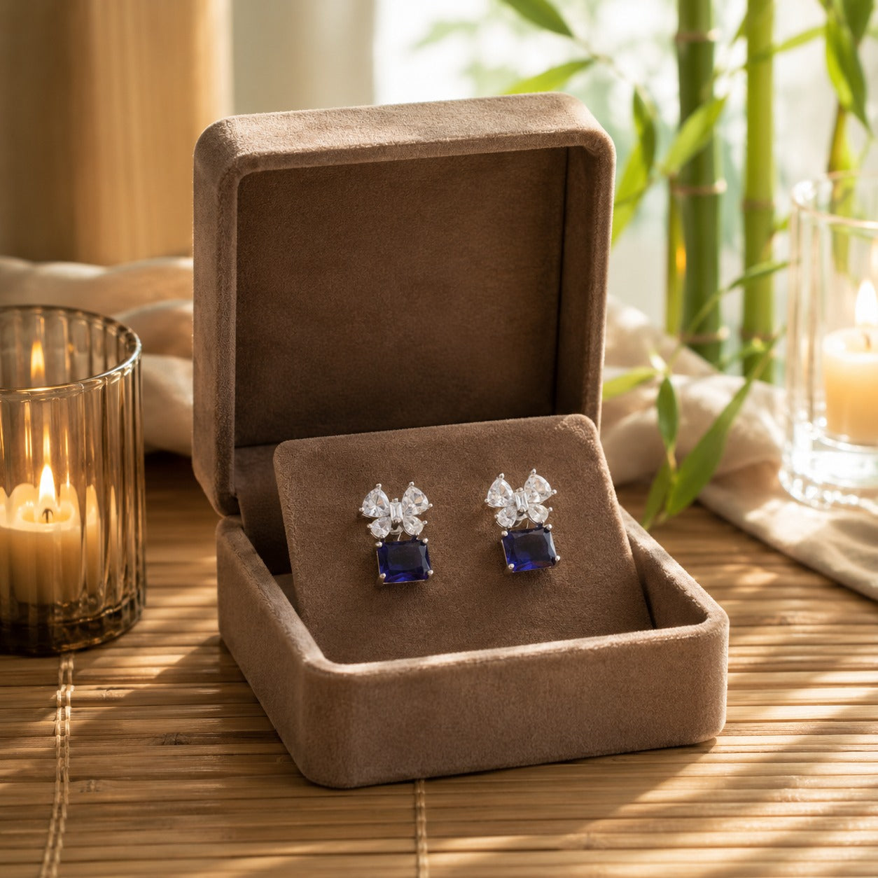 Sapphire blue floral crystal drop earrings displayed inside a premium mocha velvet jewellery box.