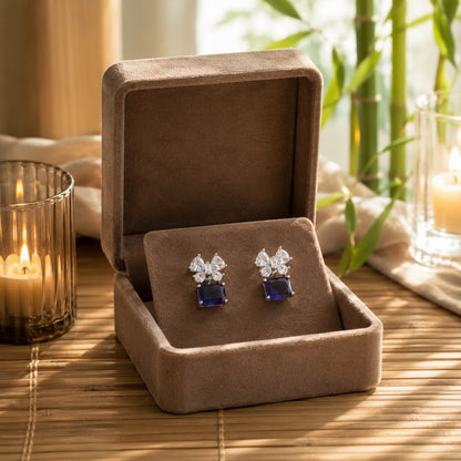 Sapphire blue floral crystal drop earrings displayed inside a premium mocha velvet jewellery box.