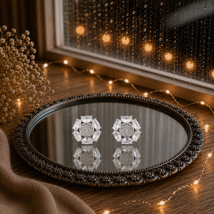 Floral crystal stud earrings with marquise-cut gemstone petals and a sparkling pavé center displayed on a decorative mirrored tray in a luxury jewelry photography setting.