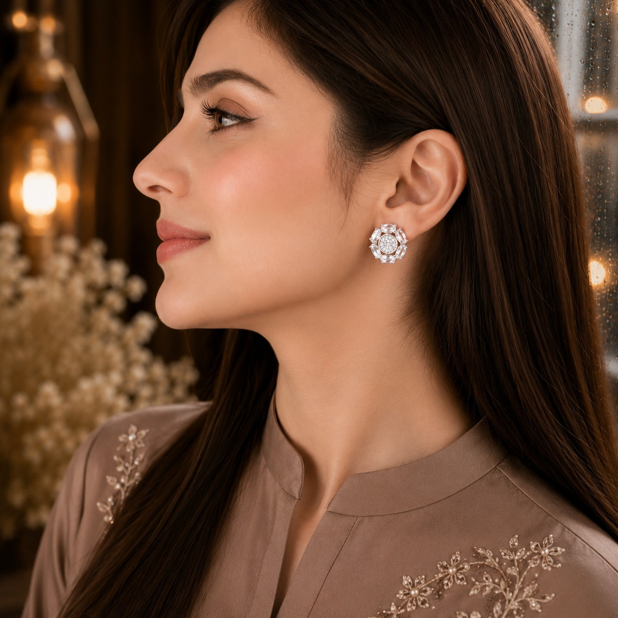 Woman wearing elegant floral crystal stud earrings with marquise-cut gemstone petals and a sparkling pavé center in a luxury side-profile portrait.
