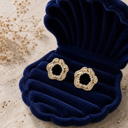 Gold open-centre floral zircon stud earrings displayed in navy velvet jewellery box