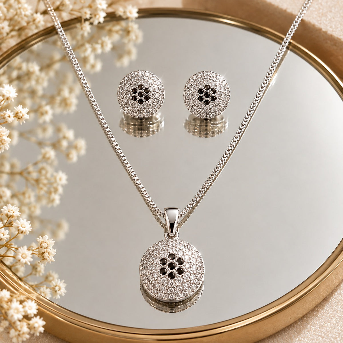 S925 silver Vela Dot earrings and pendant set displayed on a mirror, showcasing the circular textured design and clear zircon detailing.