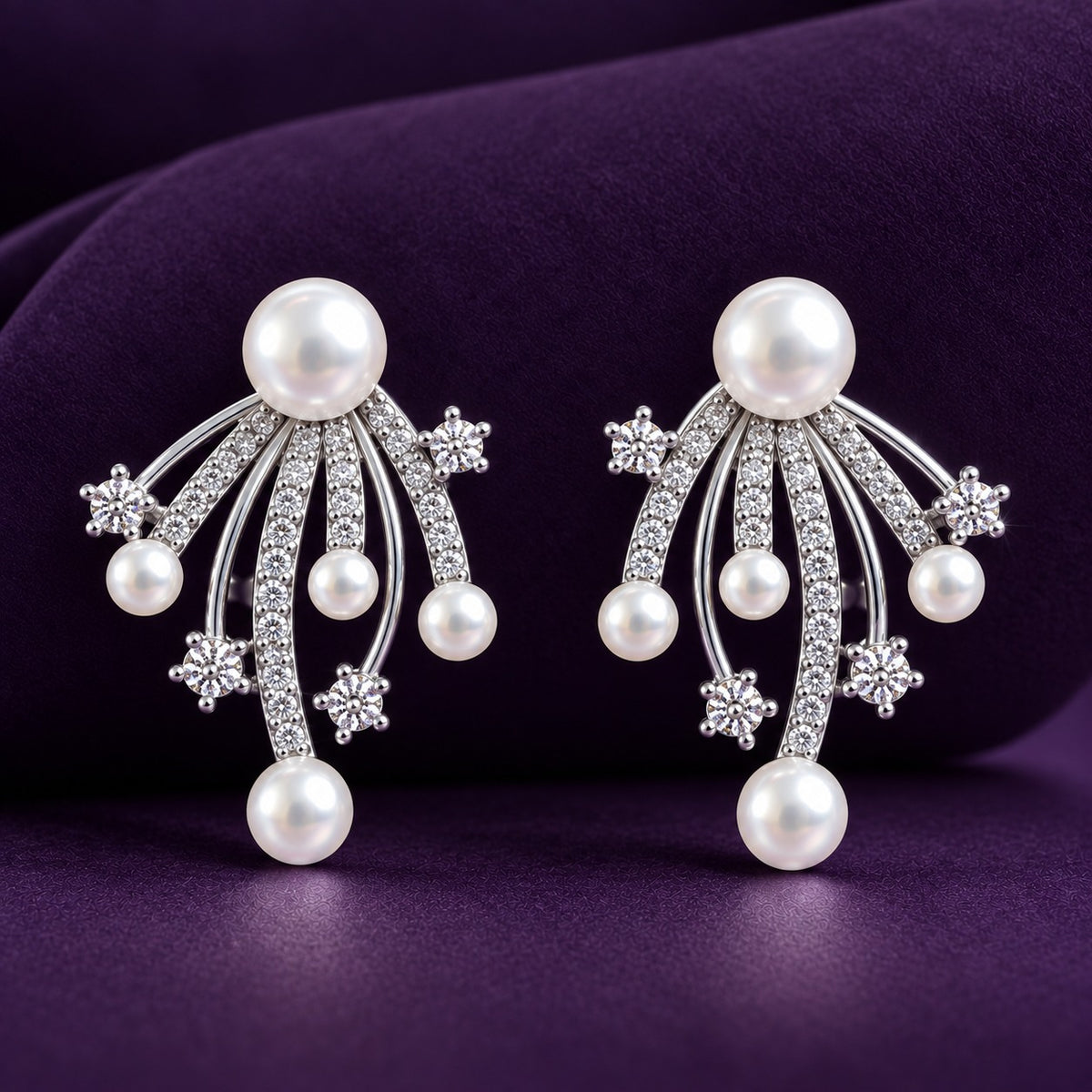 Close up of Pearl Drift Stud Earrings with white pearls, curved silver-tone strands and delicate clear zircon accents displayed on a deep purple background.