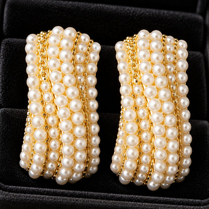 Pearl Ripple Stud Earrings featuring multiple curved rows of petite white pearls with fine gold-tone detailing, displayed in a black jewellery box.