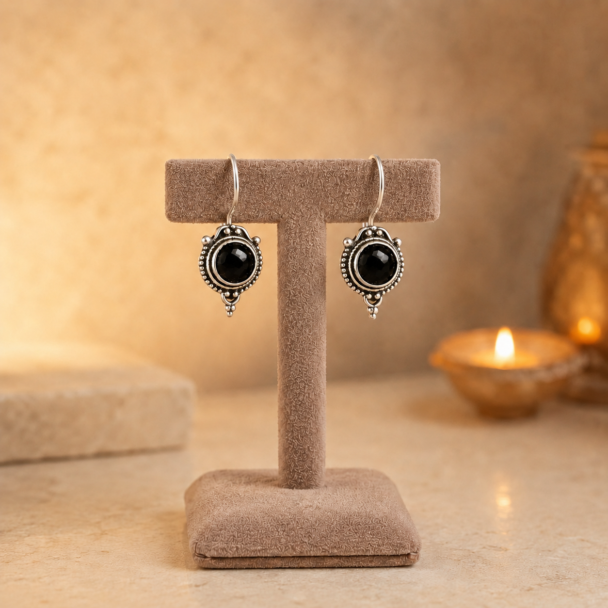 Antique silver vintage round black gemstone drop earrings on beige velvet jewellery stand with polished cabochon