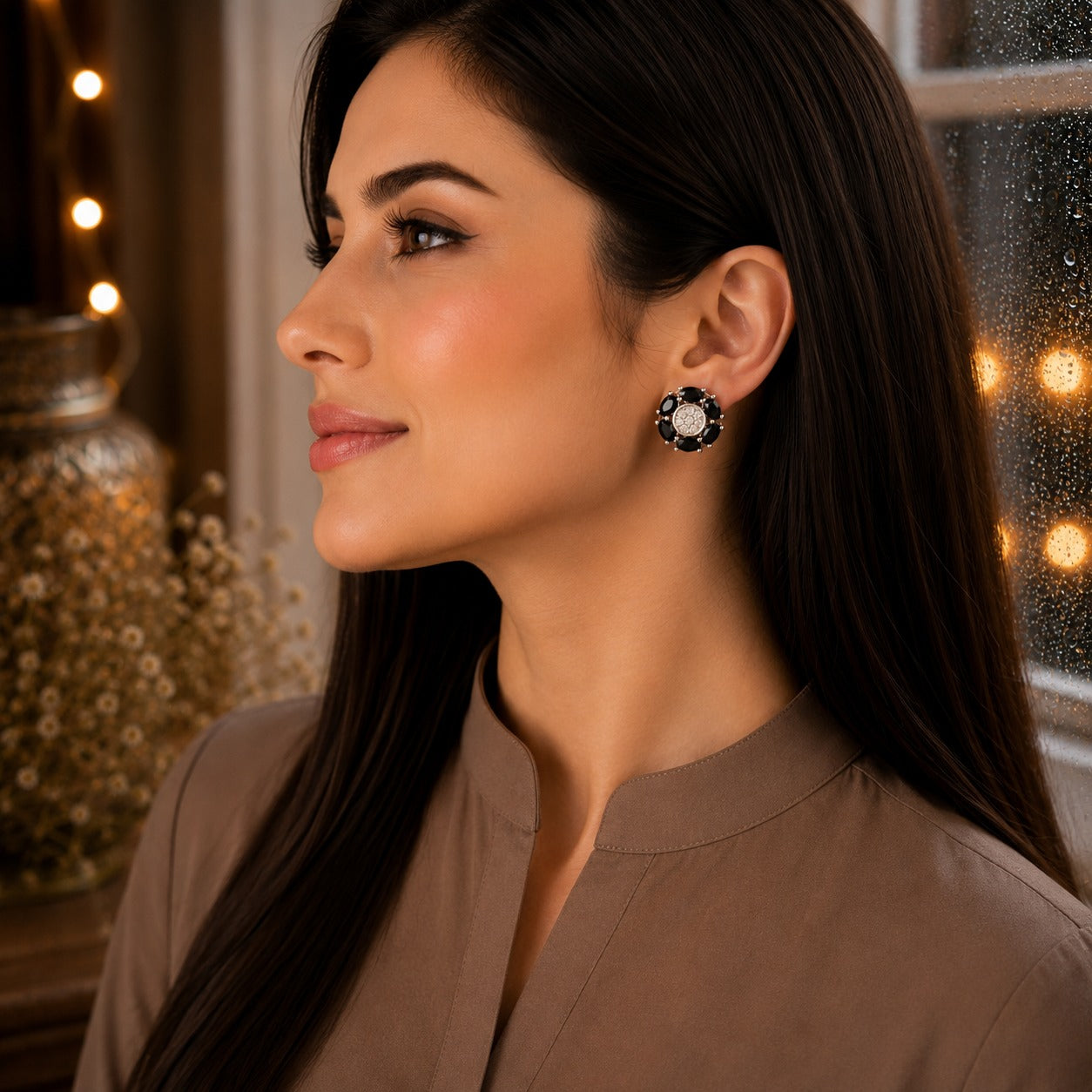 Woman wearing elegant floral  black crystal stud earrings with marquise-cut gemstone petals and a sparkling pavé center in a luxury side-profile portrait.