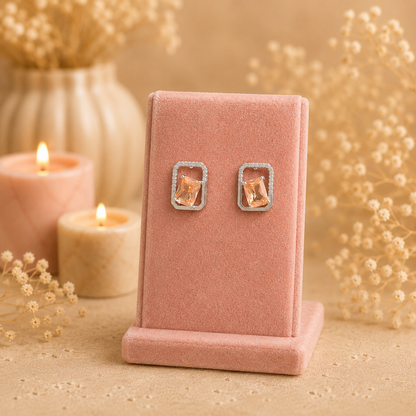 Silver geometric crystal stud earrings with rectangular faceted  champagne gemstone displayed on a premium petal pink velvet jewellery stand with a soft luxury background.