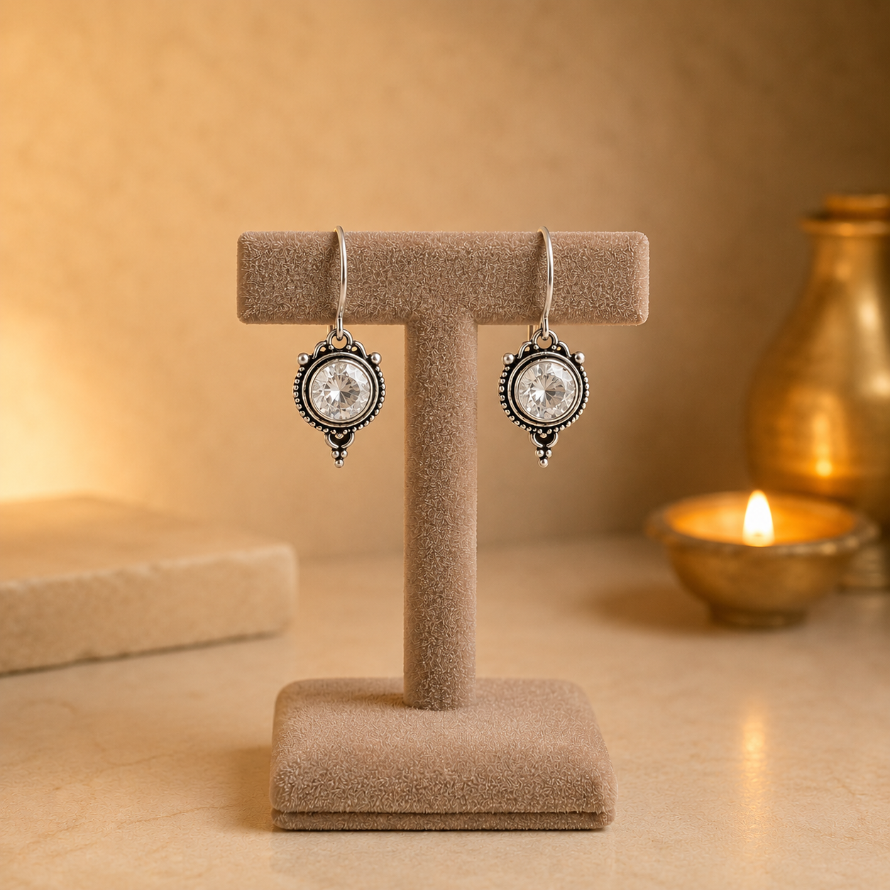 Antique silver vintage round  clear gemstone drop earrings on beige velvet jewellery stand with polished cabochon