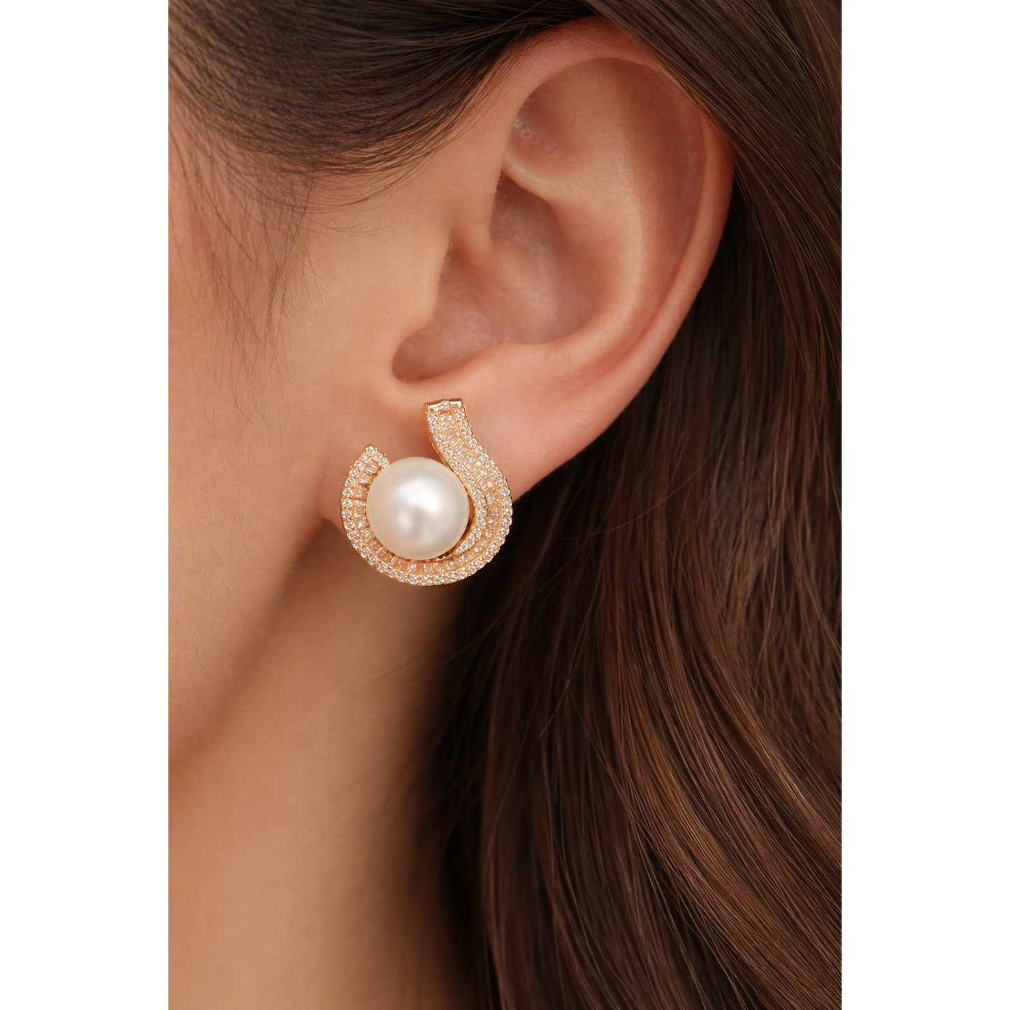 Close-up of TIAS pearl gold stud earrings with crystal accents worn on ear, highlighting timeless elegance and refined design