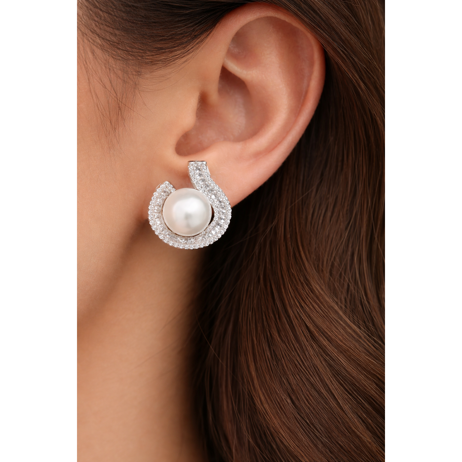 Close-up of TIAS pearl  silver stud earrings with crystal accents worn on ear, highlighting timeless elegance and refined design