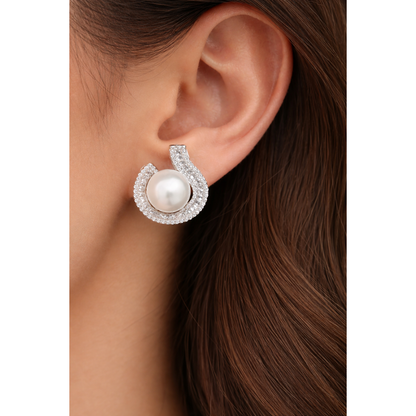 Close-up of TIAS pearl  silver stud earrings with crystal accents worn on ear, highlighting timeless elegance and refined design