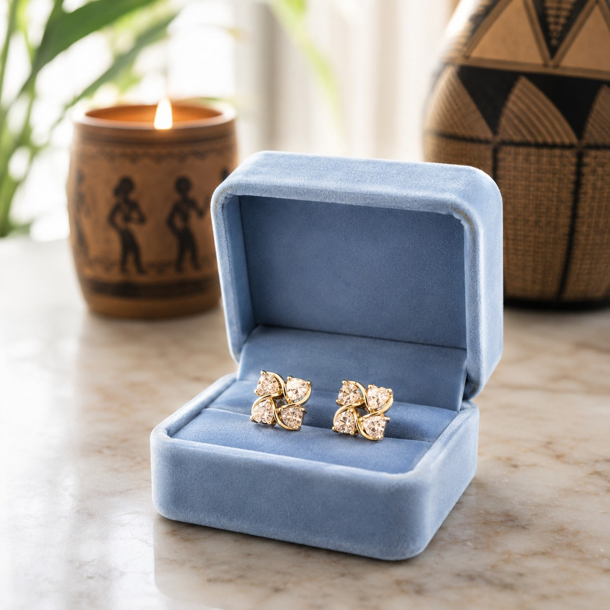Crystal floral stud earrings displayed in a premium powder blue velvet jewellery box on a marble surface with a softly blurred luxury background.