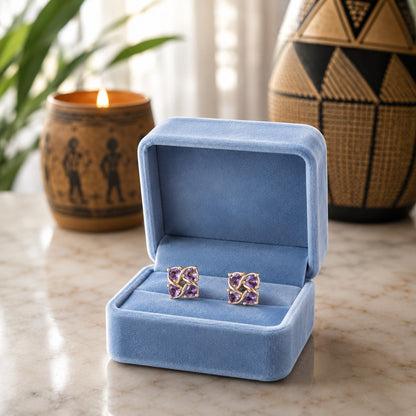 Crystal floral stud earrings displayed in a premium powder blue velvet jewellery box on a marble surface with a softly blurred luxury background.