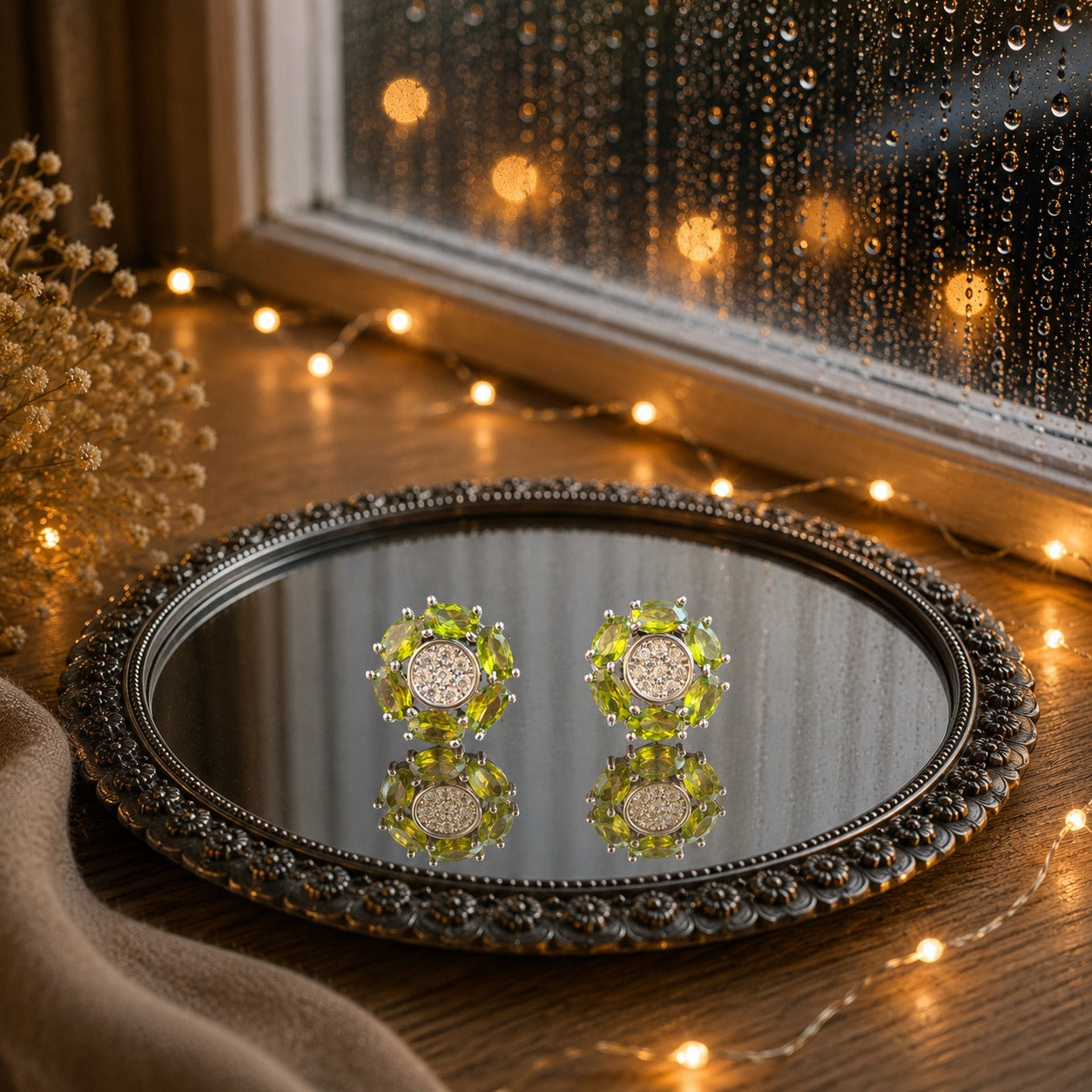 Floral crystal stud earrings with marquise-cut  lime green gemstone petals and a sparkling pavé center displayed on a decorative mirrored tray in a luxury jewelry photography setting.