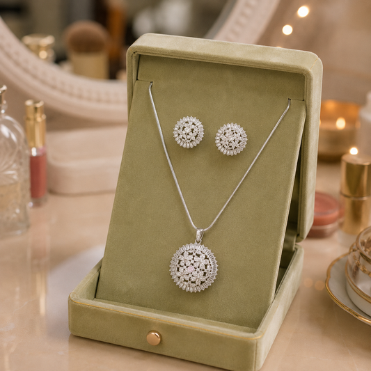 Silver floral crystal pendant necklace and matching stud earrings displayed in a premium sage green velvet jewellery box, available with crystal clear or soft pale pink center stone.