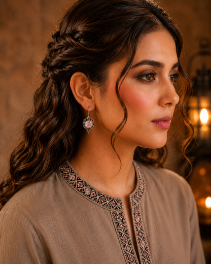 Woman wearing antique pink round gemstone drop earrings with vintage detailing and embroidered taupe kurta, side profile jewellery photography.
