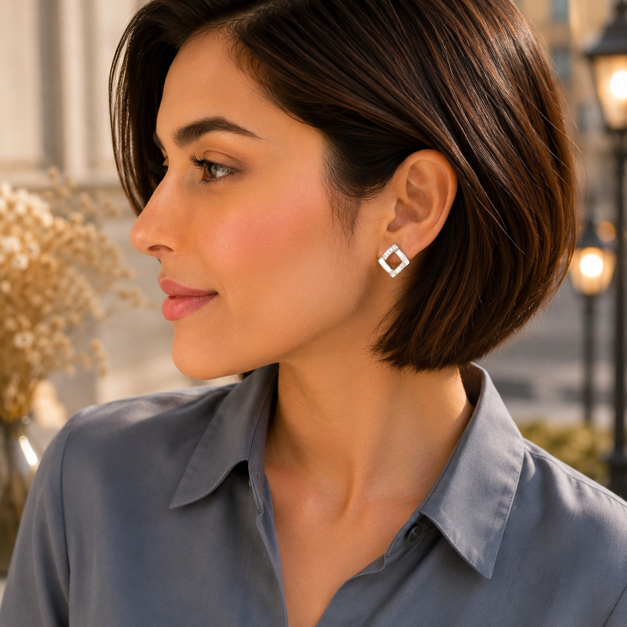 Woman wearing white geometric square crystal stud earrings with a modern open-square design and sparkling crystal accents.