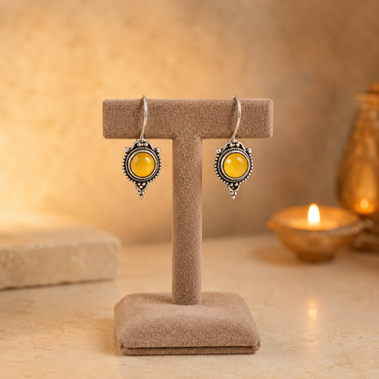Antique silver vintage round  yellow gemstone drop earrings on beige velvet jewellery stand with polished cabochon